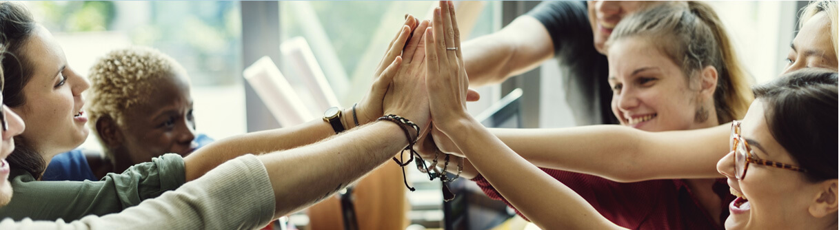 Várias pessoas encostando suas mãos como um 'High Five'