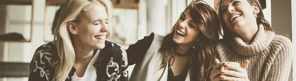 Três mulheres rindo e se divertindo
