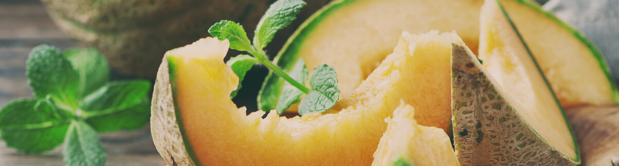 Melão cortado com algumas folhas de hortelã