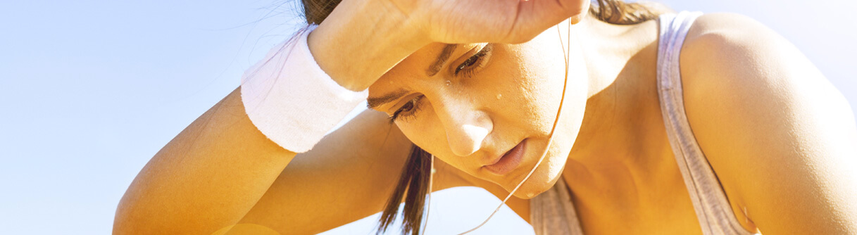 Mulher limpando o suor da testa