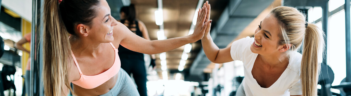Mulheres fazendo exercício e se motivando fazendo um 'High Five'