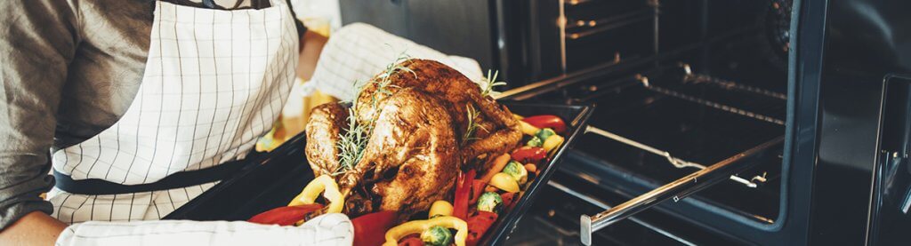 Pessoa colocando Peru no forno