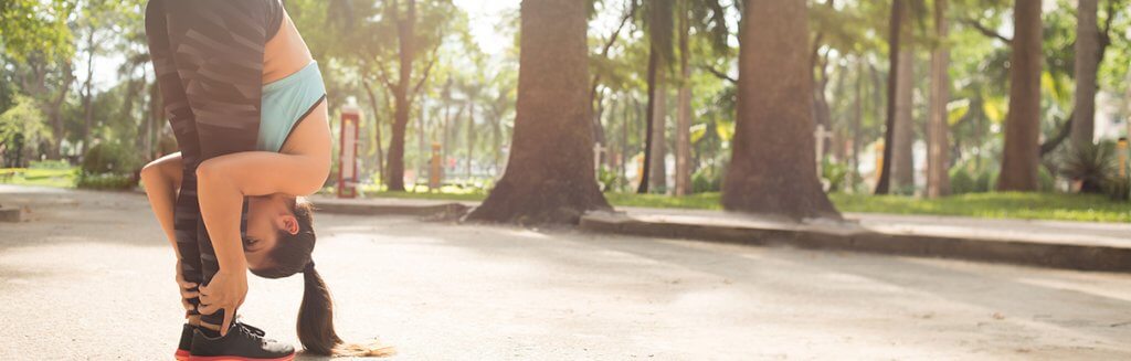 Mulher praticando Yoga: com a cabeça inclinada chegando perto de seus pés