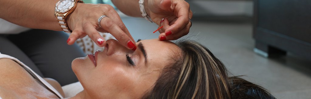 Mulher de olhos fechados recebendo um tratamento de estresse