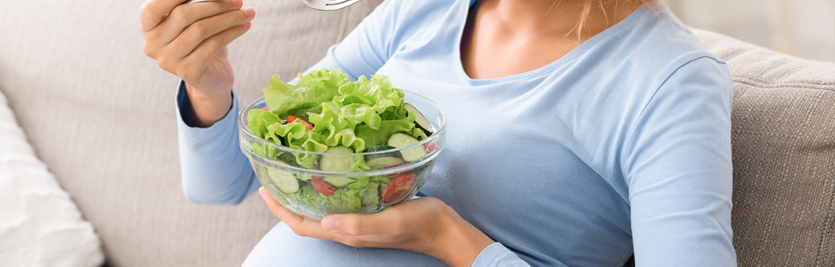 Mulher grávida com uma tijela de salada