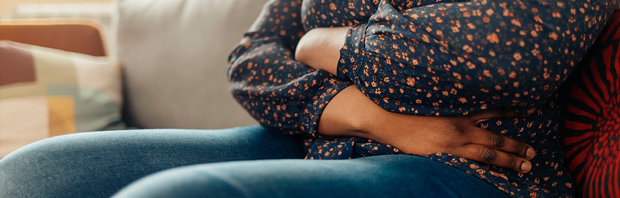 Mulher sentada com as mãos na barriga