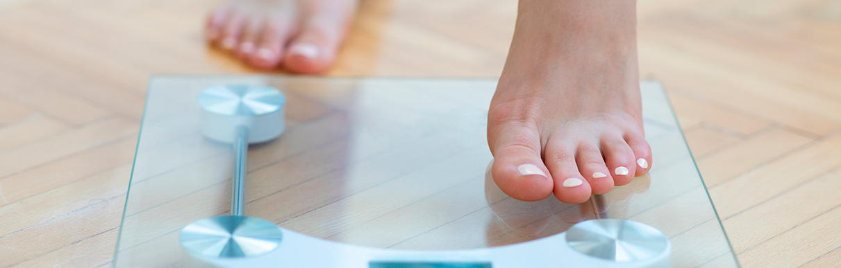 Pés de uma pessoa subindo em uma balança