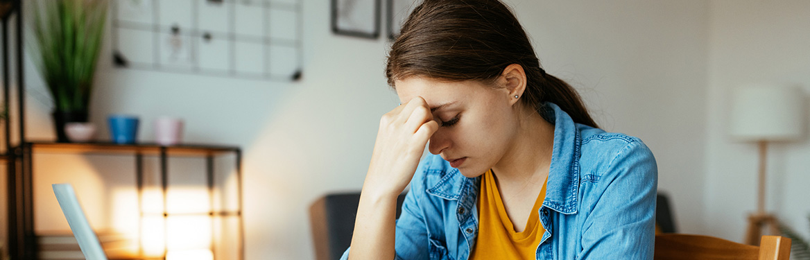 Mulher com a cabeça baixa pensativa